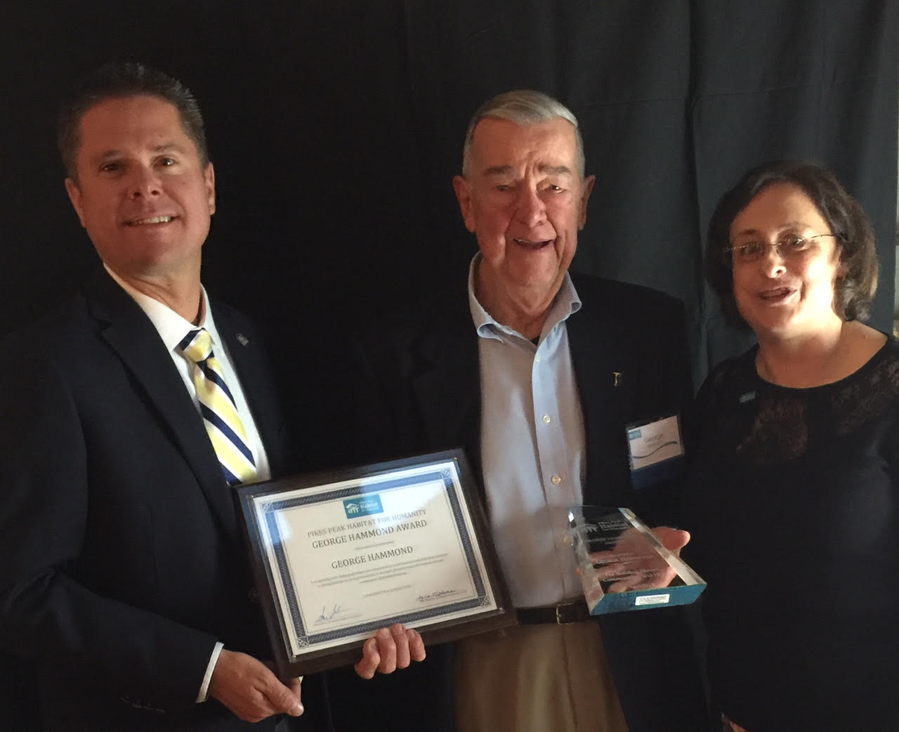 Three people holding award