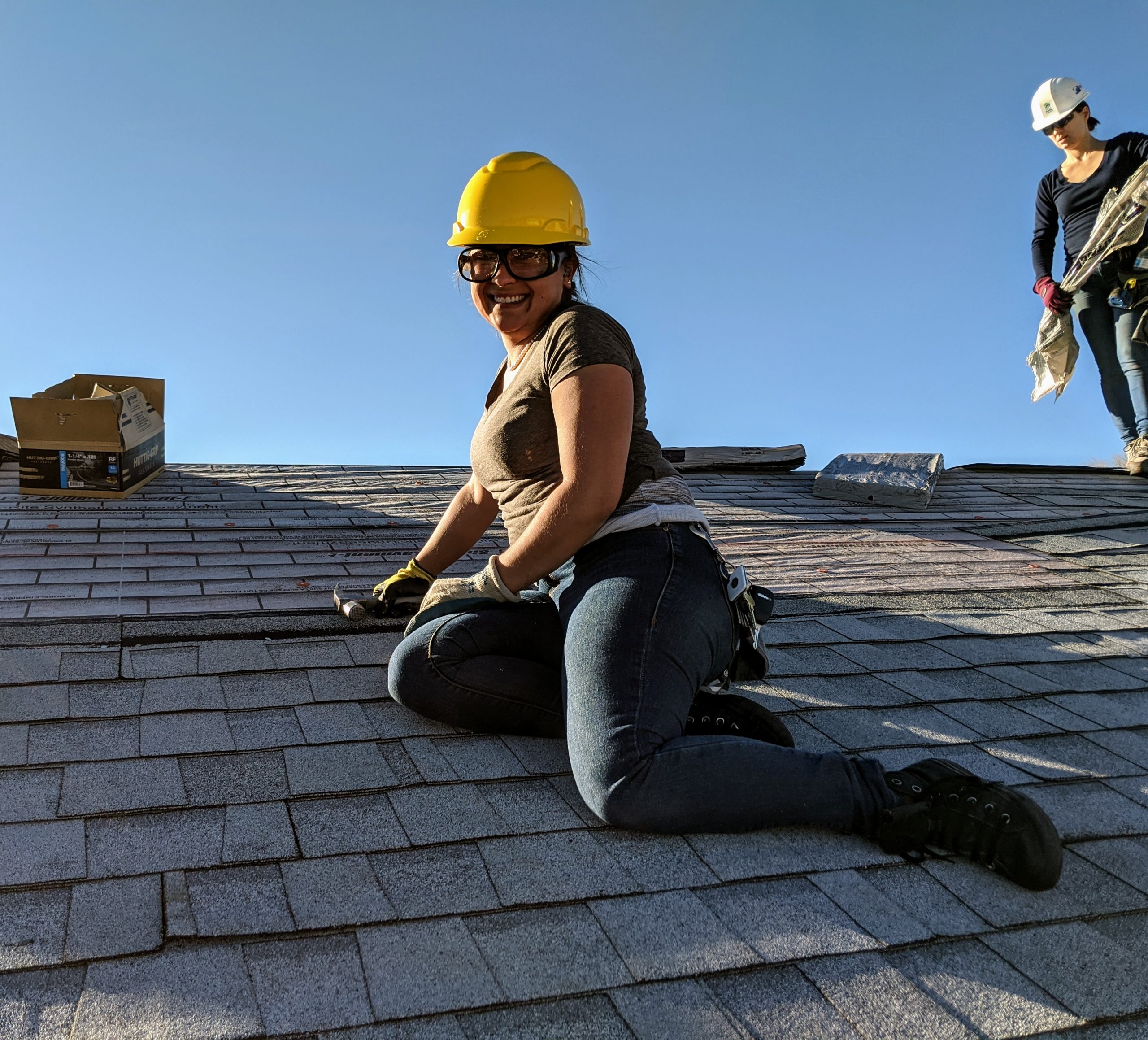 Woman in a hard hat sitting on a roof