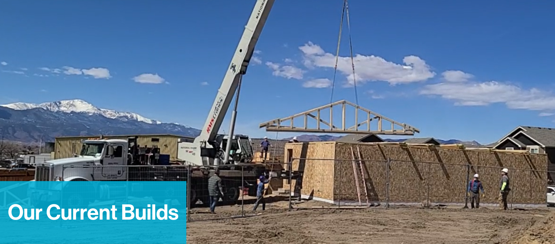 Our Current Builds text with image of trusses being lowered onto house frame