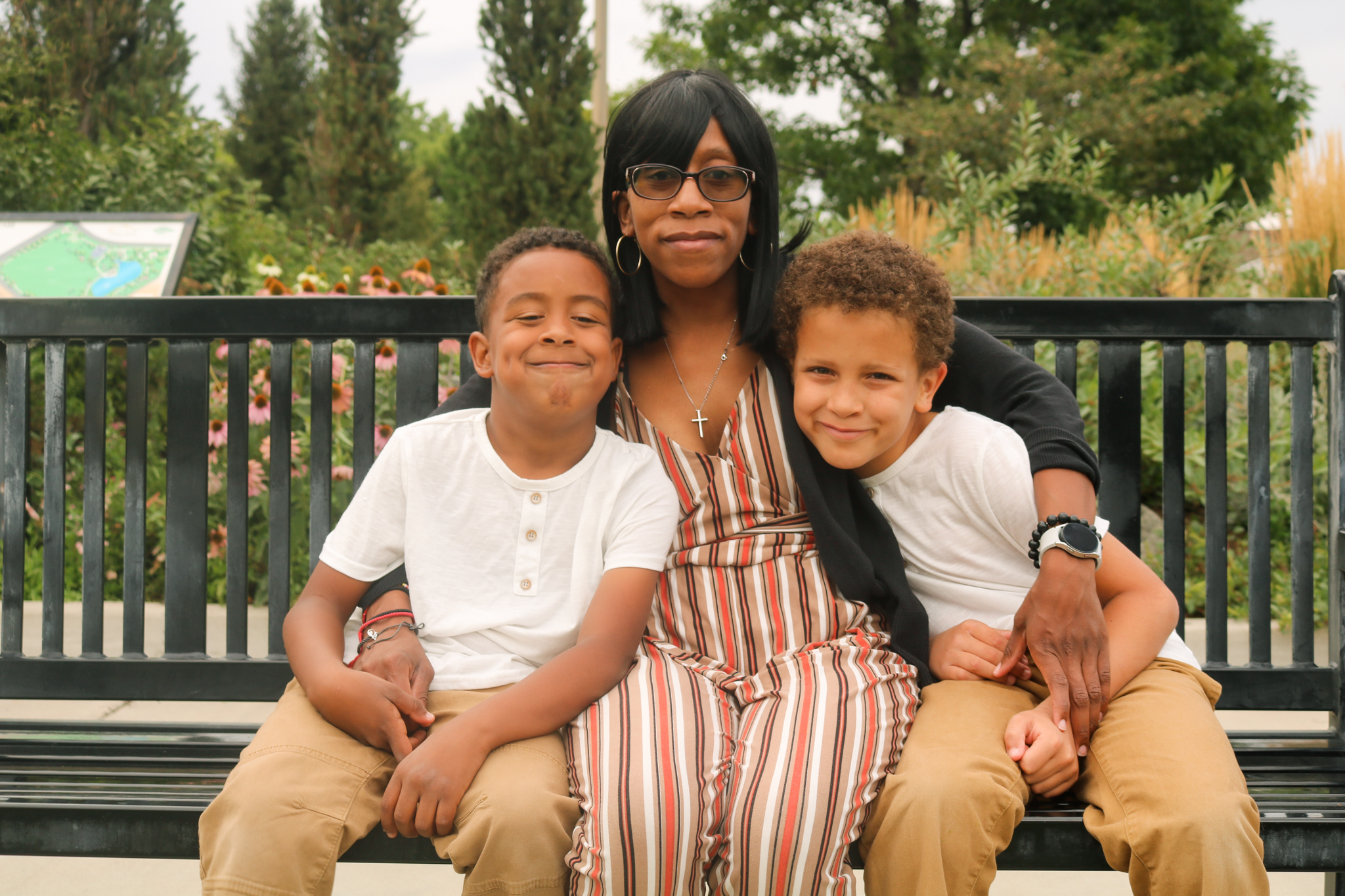 Mom and two sons sitting on park bench