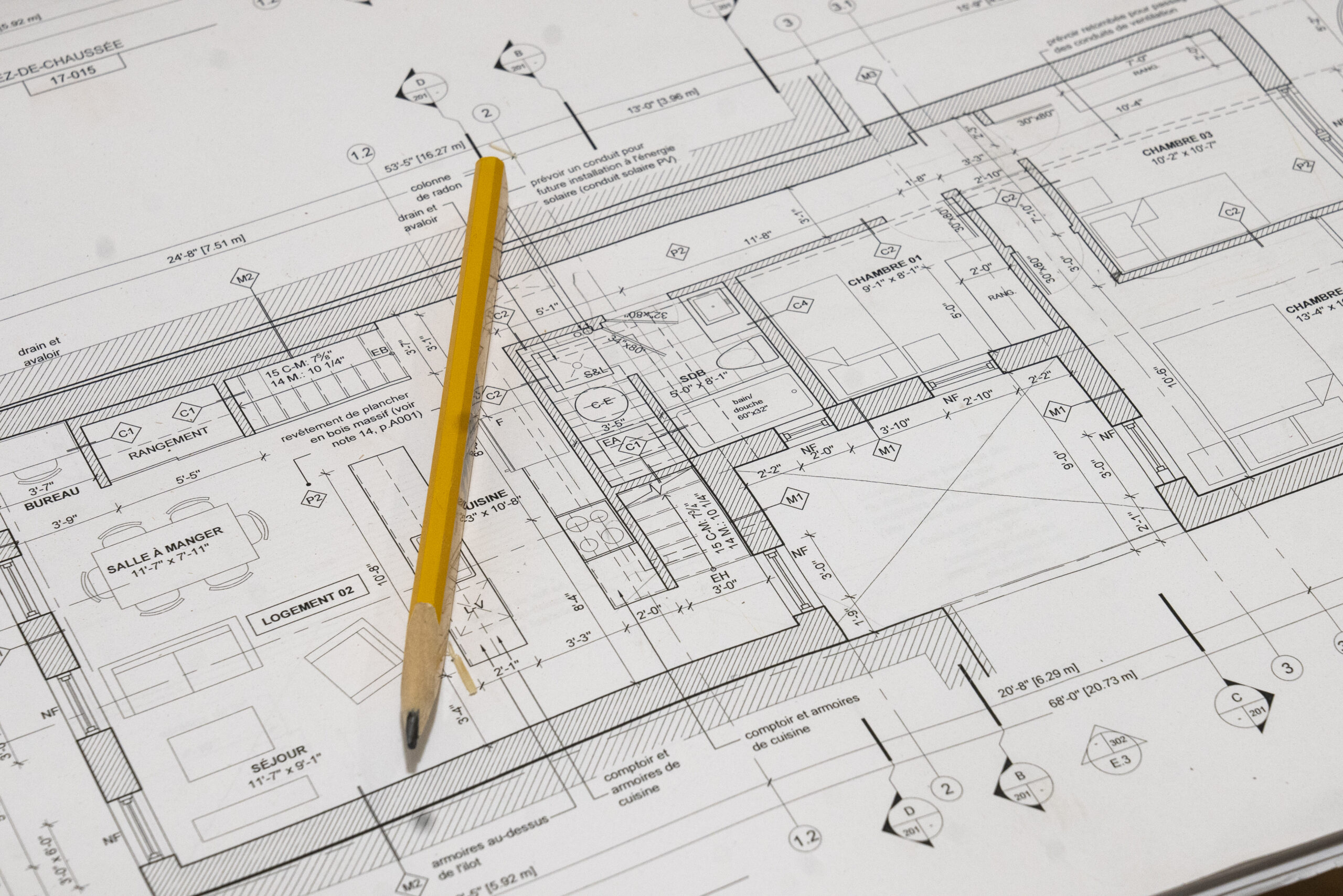 A pencil resting on home blueprints