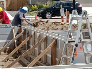 Volunteers spreading concrete in buttressed frame