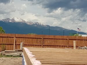View of Pikes Peak, fence, and home foundation