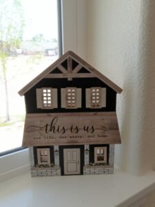 Cutout of a house reading "This is us!"
