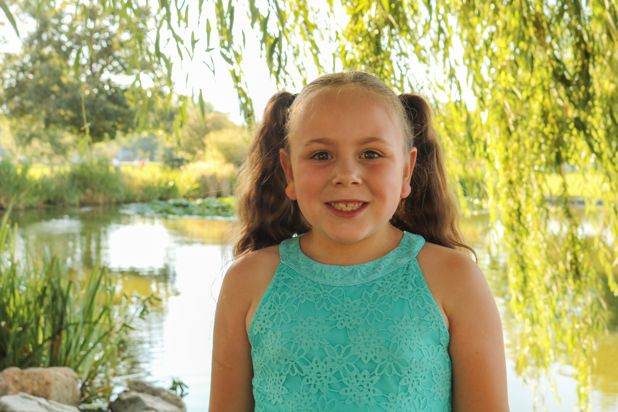 Girl smiling in front of pond