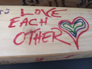 Board painted with words "Love each other"