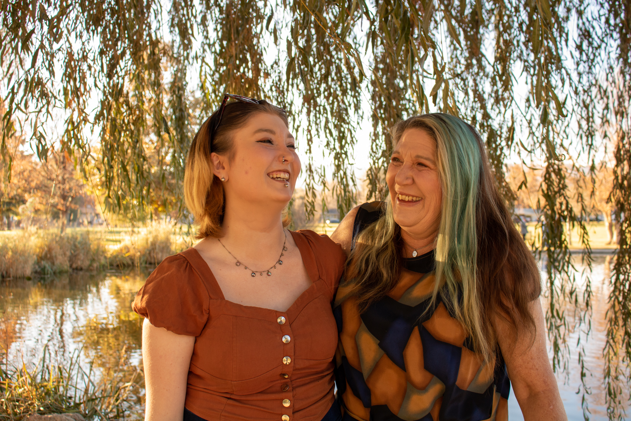 Mother and daughter laughing by lake