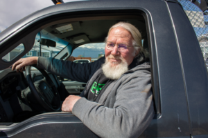 Man sitting in cab of pickup truck