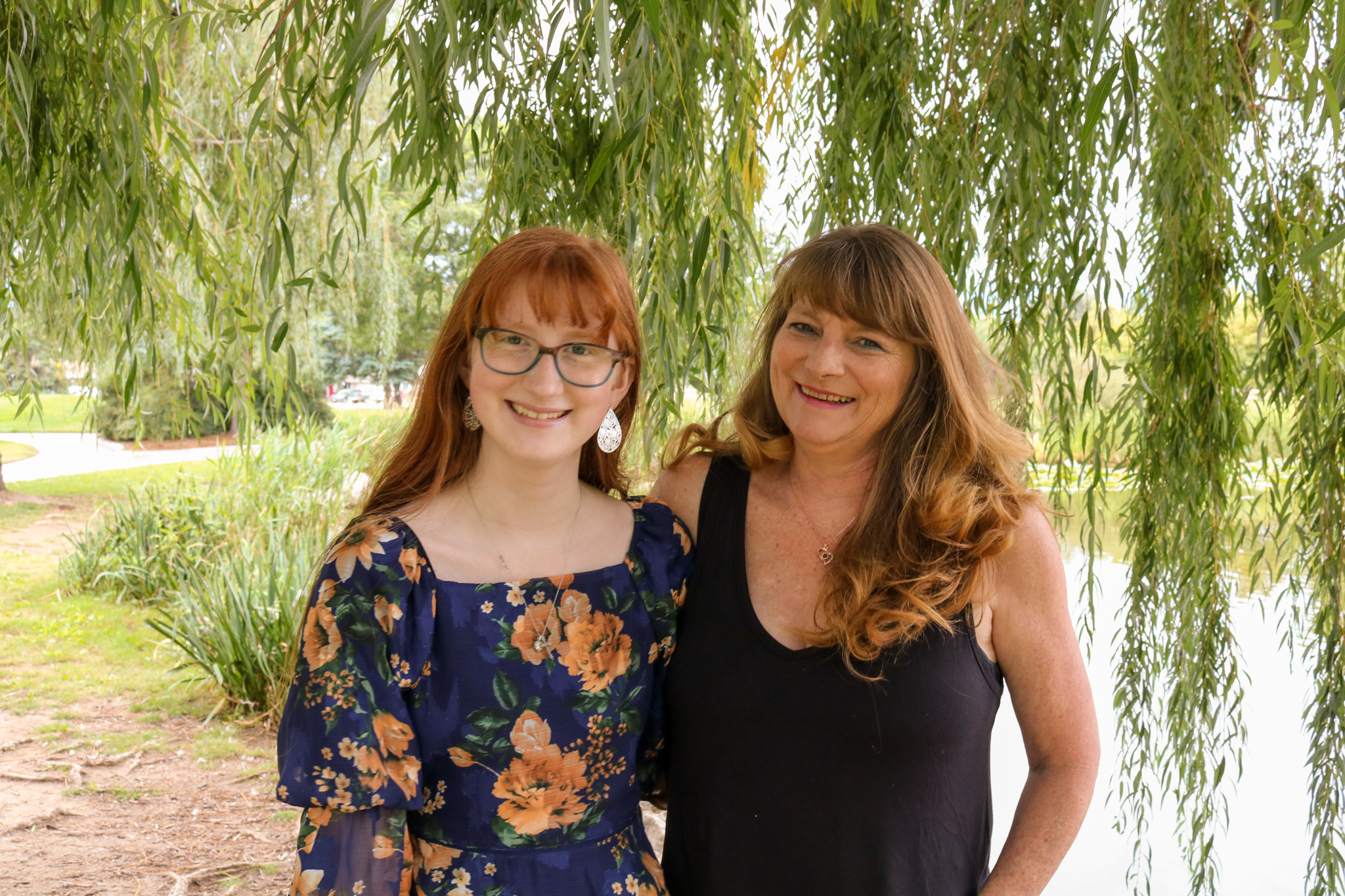 Mother and daughter in front of a willow tree