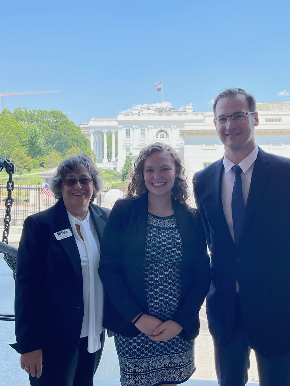 Three people with the White House in the background