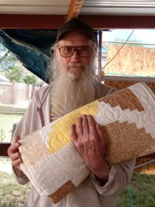 Man holding a quilt