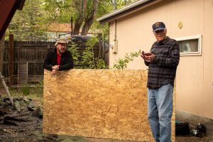 Men standing near plywood sheet