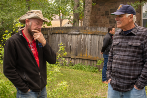 Men talking in a yard