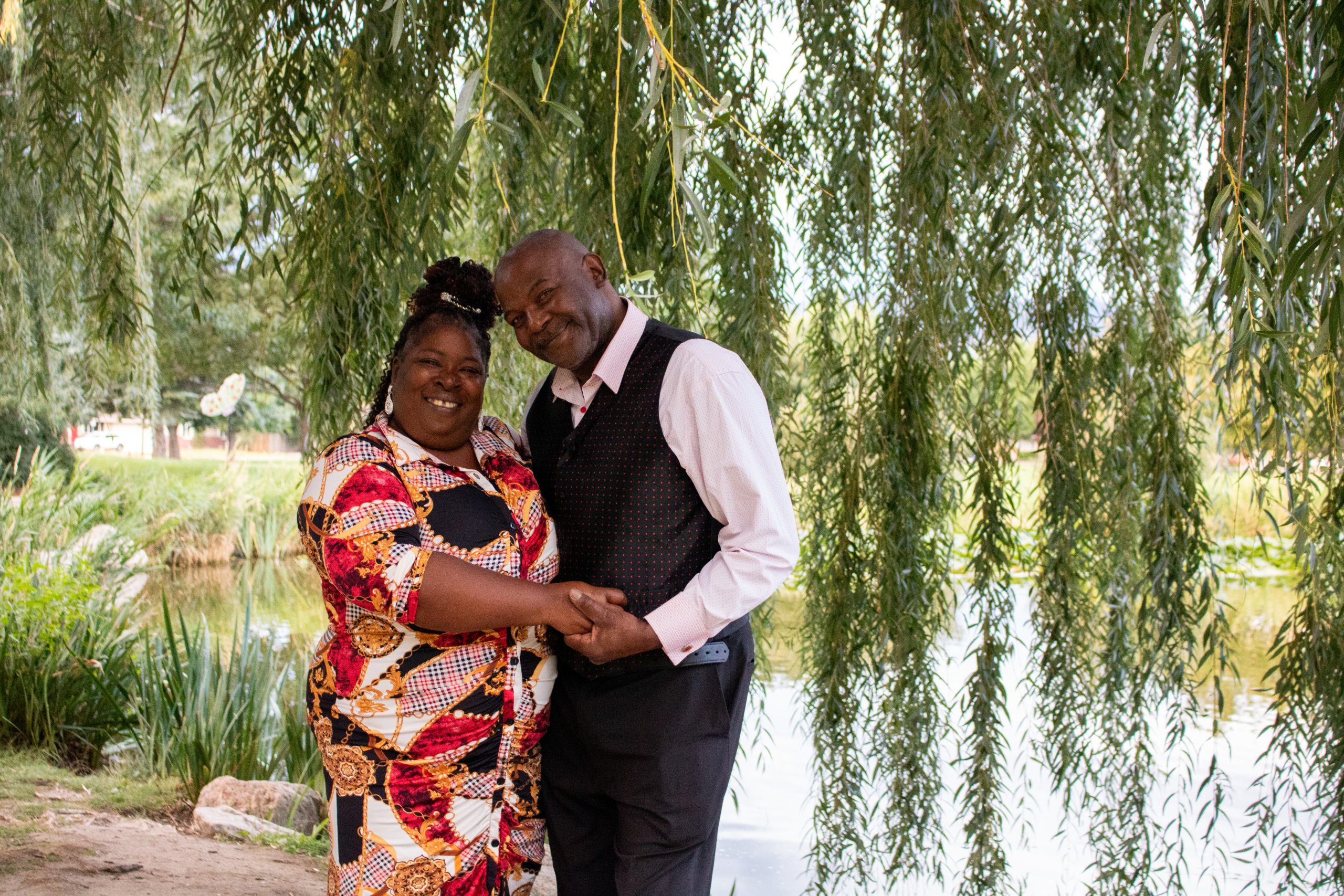 Smiling couple posing under a tree