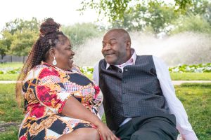 Couple sitting on ground smiling at each other