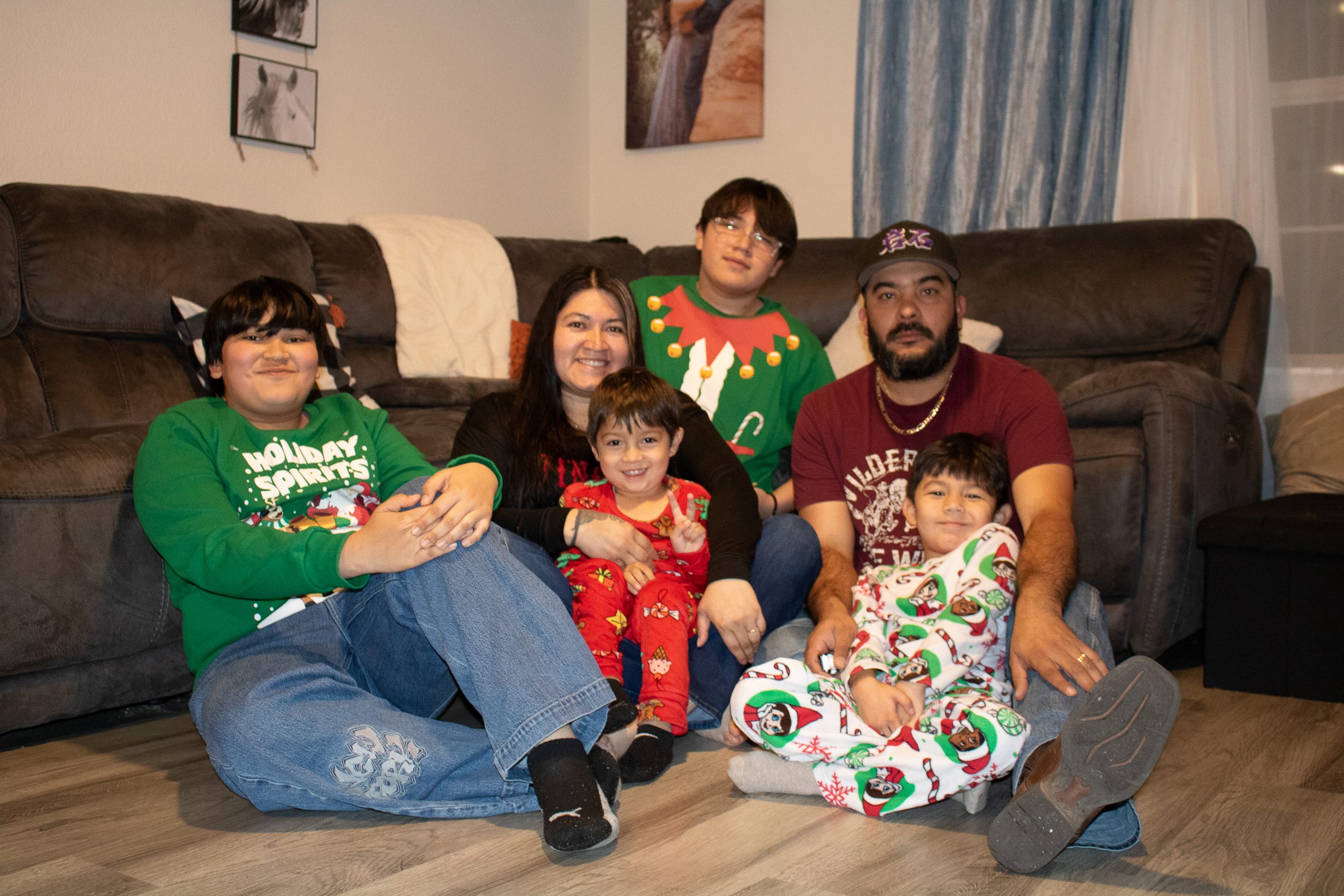 Family sitting on floor in front of living room couch